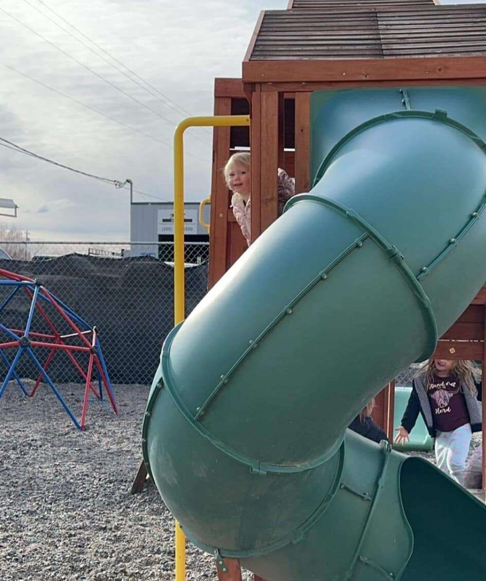 Child playing on a playground at a full-time childcare center in Filer, ID
