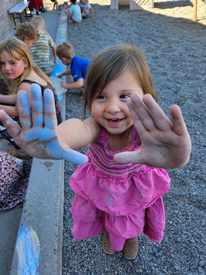 Kids playing with chalk at a trusted daycare serving Twin Falls and Filer families