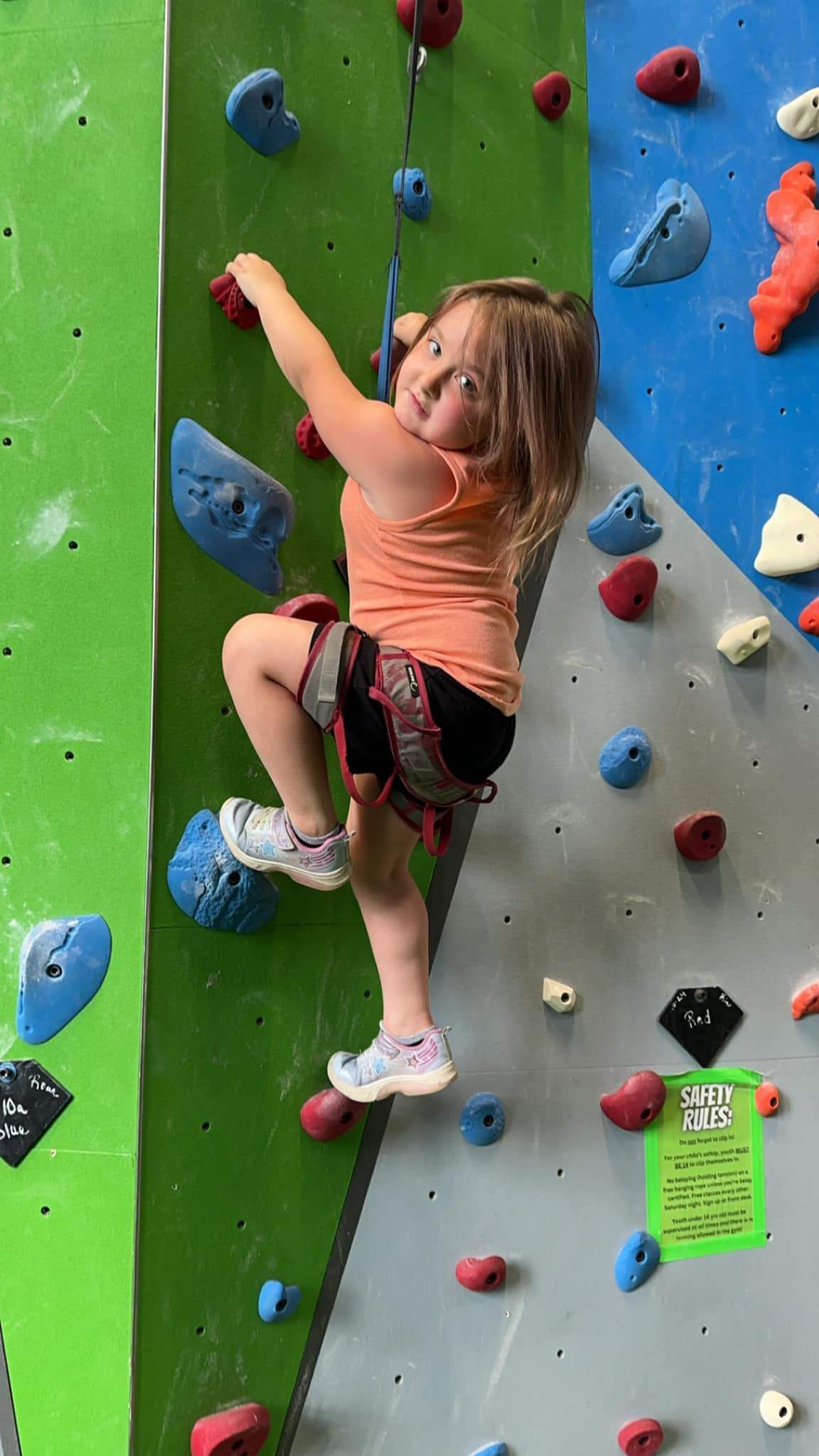Child rock climbing during enrichment activities at a childcare center in Filer, ID