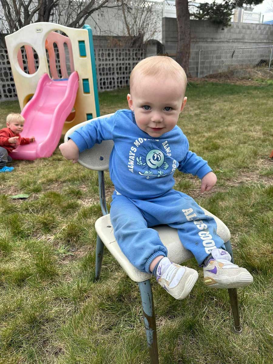 Toddler sitting on playground chair at a structured toddler care center in Twin Falls, ID